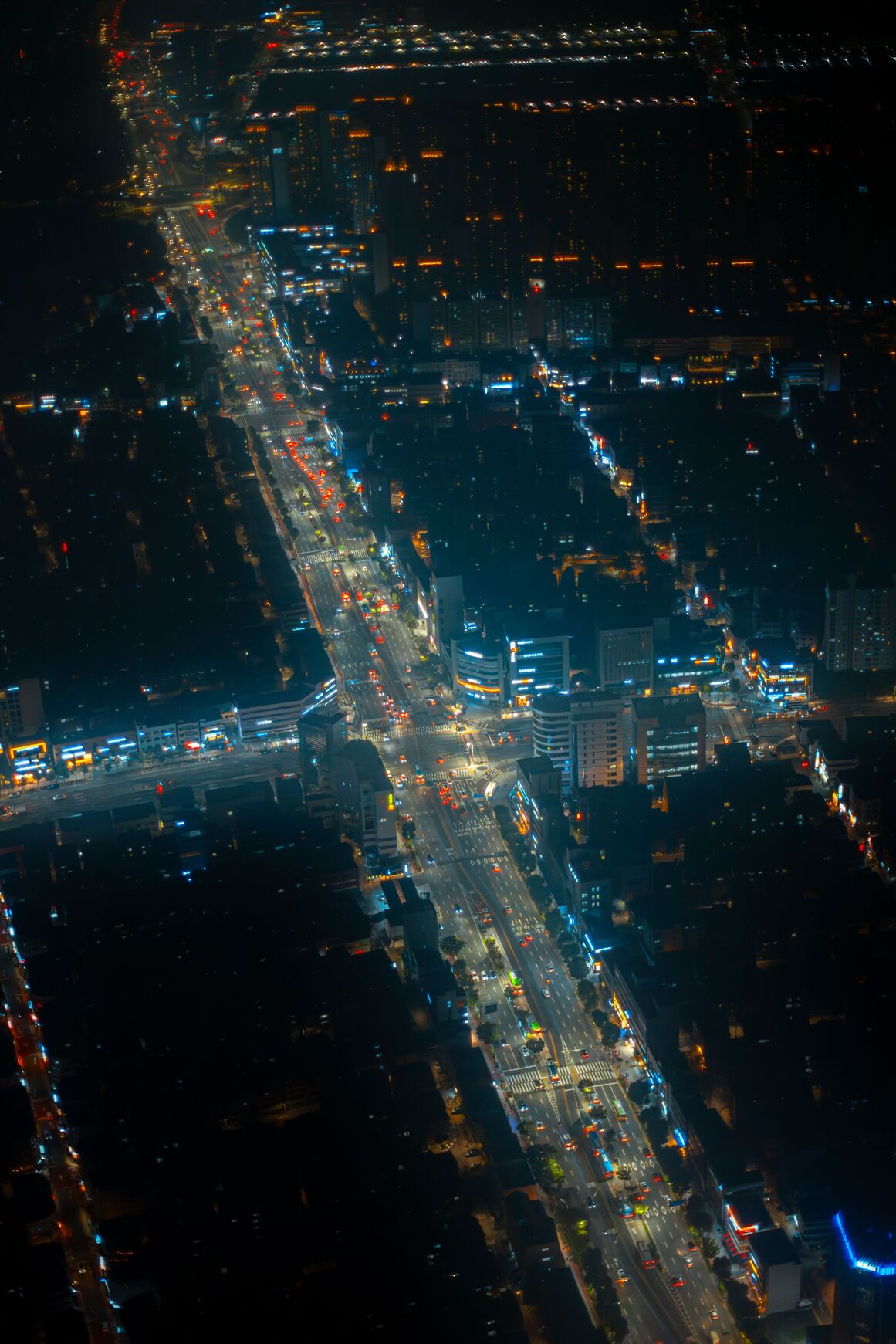 Night aerial view of a long lit city avenue